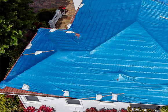 Emergency roof tarping in progress